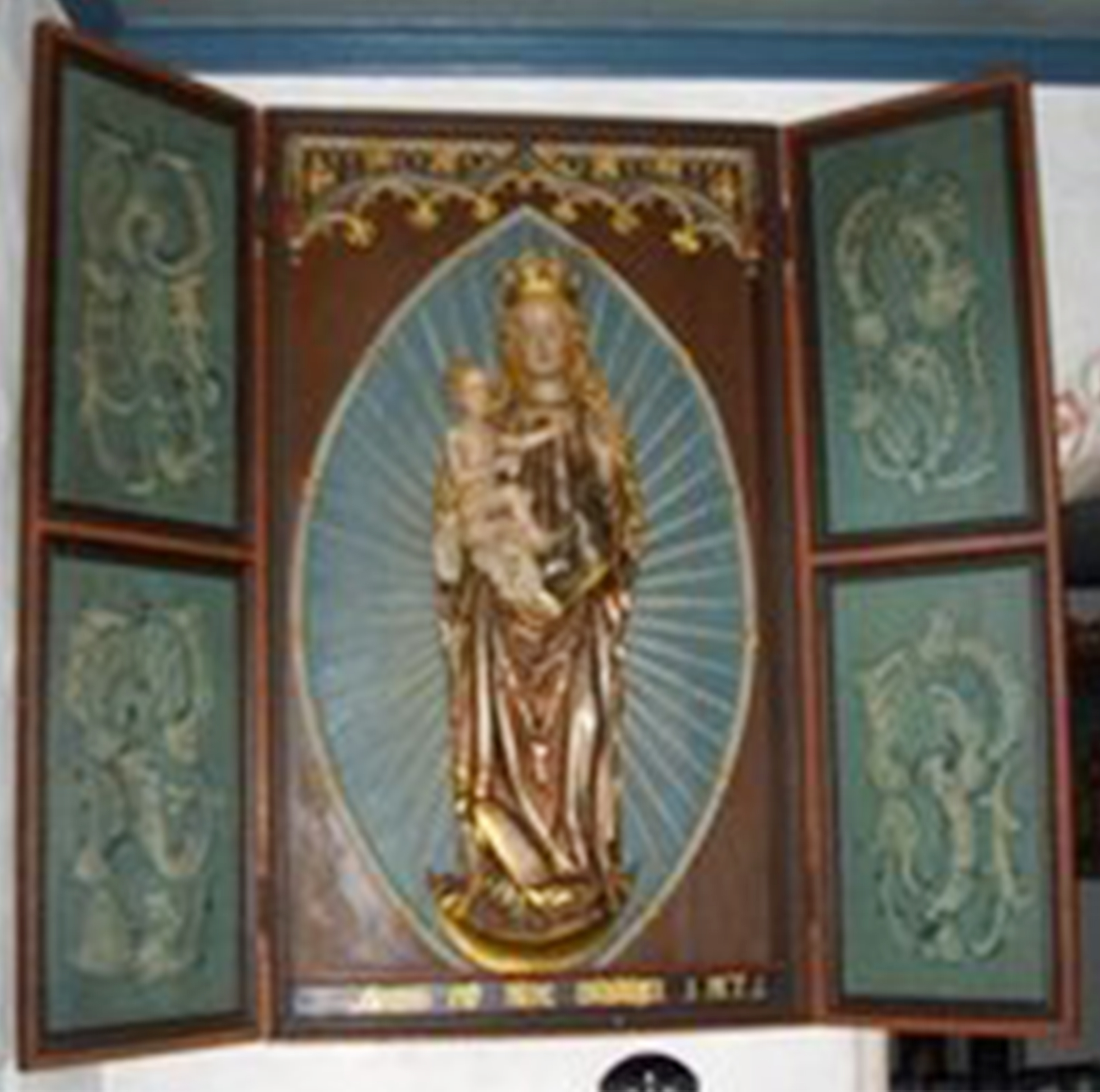 Billede af et kirkeligt altertavle med en statue af Jomfru Maria og Jesusbarnet.